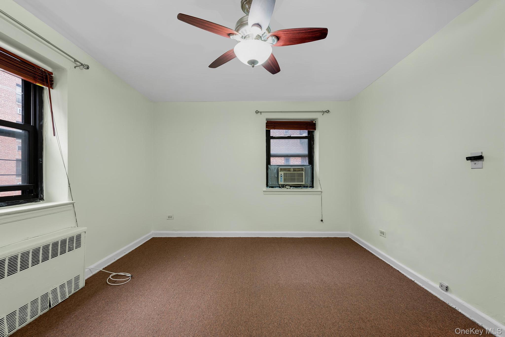 102-25 67th Road, Unit 3C Queens, NY 11375 - Photo 16 of 17 Unfurnished room featuring radiator heating unit, carpet, and ceiling fan