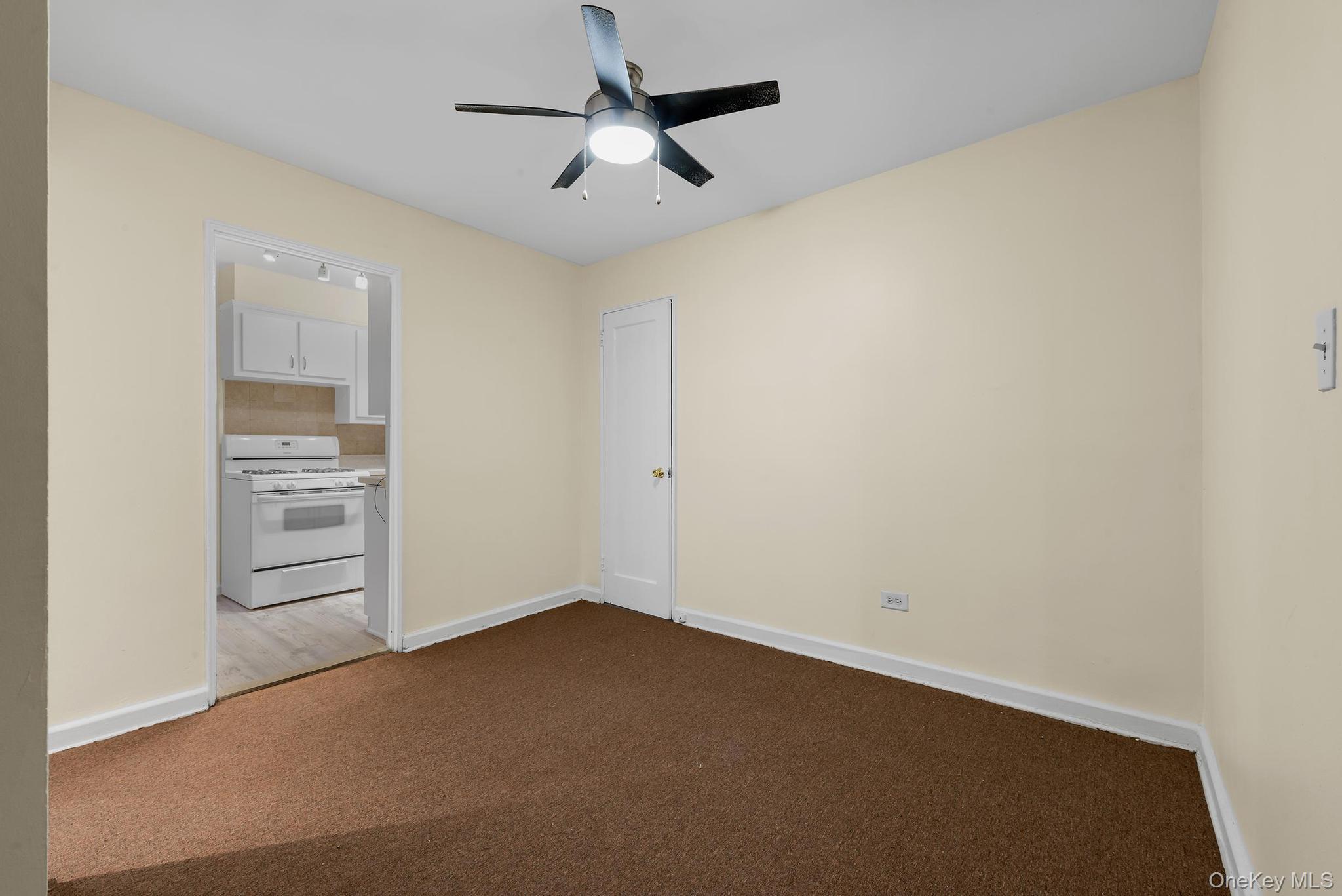 102-25 67th Road, Unit 3C Queens, NY 11375 - Photo 7 of 17 Unfurnished room with carpet floors and a ceiling fan