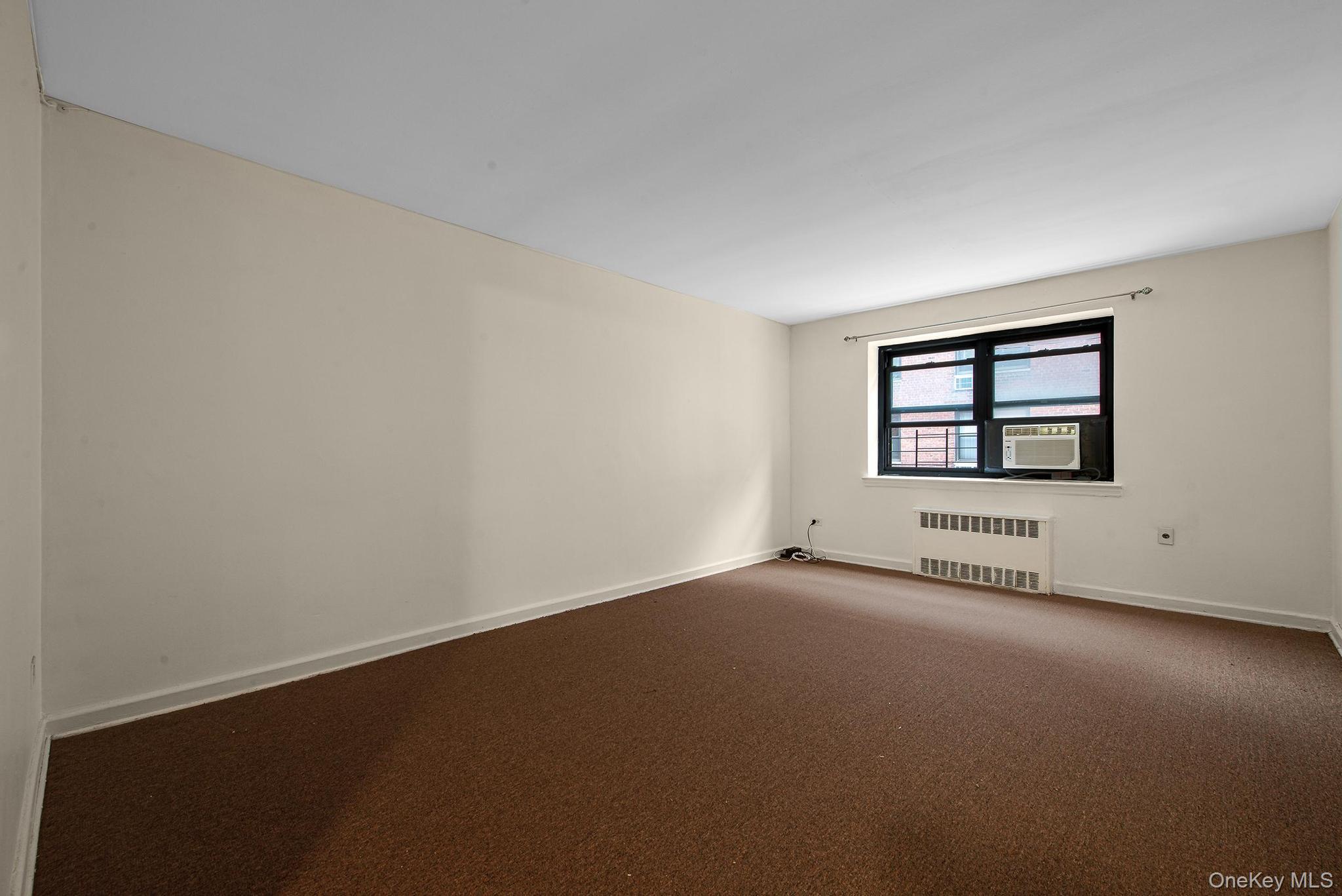 102-25 67th Road, Unit 3C Queens, NY 11375 - Photo 10 of 17 Carpeted empty room with radiator and baseboards