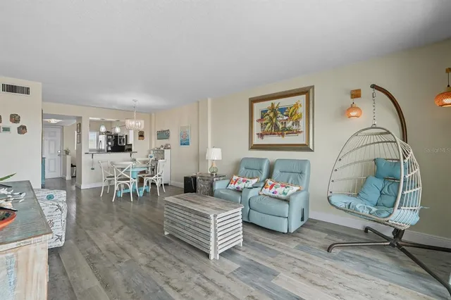 a living room with furniture a table and wooden floor