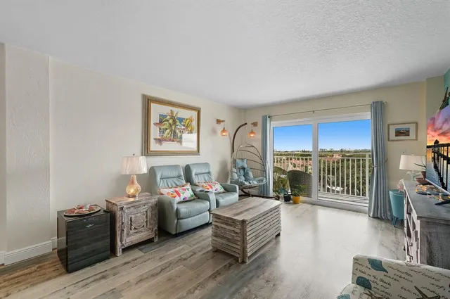 a living room with furniture a bookshelf and a wooden floor
