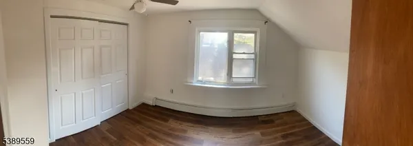 a view of a livingroom with wooden floor and window