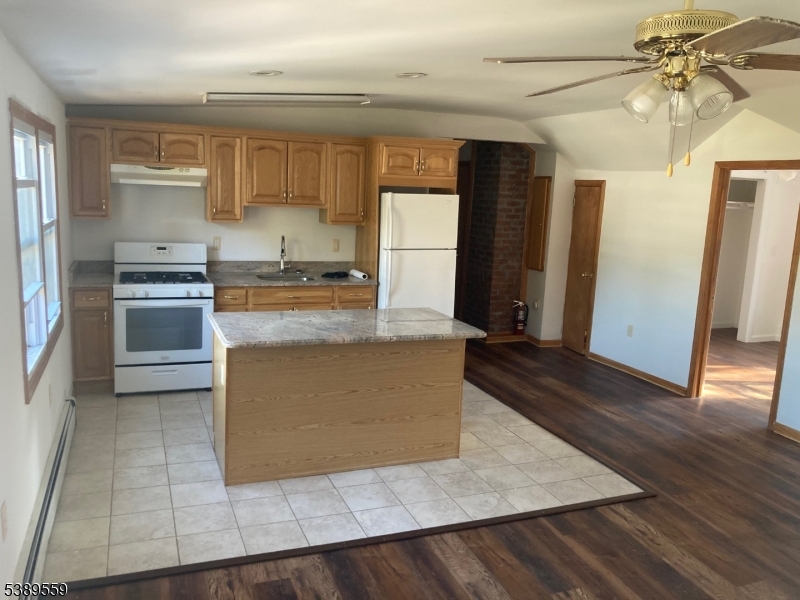 9 Orchard Street Passaic, NJ 07055 - Photo 5 of 19 a kitchen with stainless steel appliances granite countertop a refrigerator a stove and a sink