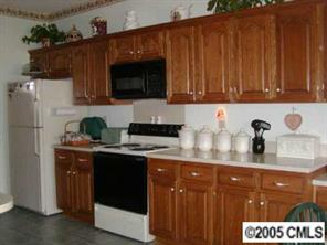 9837 Fairway Ridge Road Charlotte, NC 28277 - Photo 2 of 8 a kitchen with stainless steel appliances wooden cabinets and a sink