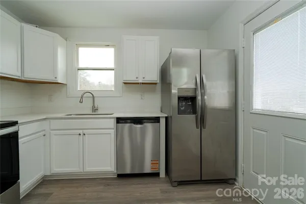 a kitchen with stainless steel appliances granite countertop a sink and a microwave