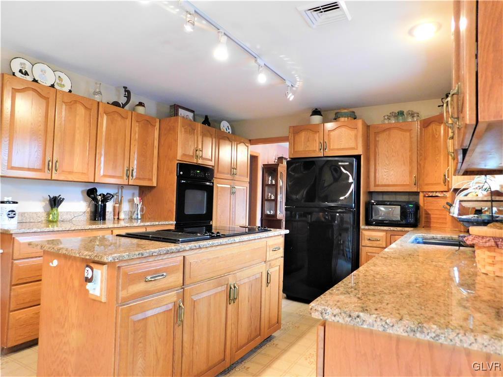 1123 Bangor Road Nazareth, PA 18064 - Photo 11 of 49 a kitchen with stainless steel appliances granite countertop a refrigerator a stove and a sink with wooden cabinets