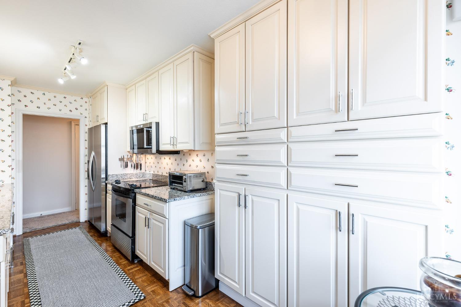 2444 Madison Road, Unit 901 Cincinnati, OH 45208 - Photo 9 of 44 The updated and well-equipped kitchen boasts an abundance of crisp white cabinetry trimmed with crown molding, a convenient walk-in pantry, granite countertops, stainless steel appliances and hardwood floors.