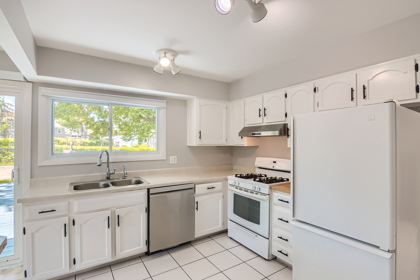 424 North Salem Drive Schaumburg, IL 60169 - Photo 6 of 26 a kitchen with white cabinets and white appliances