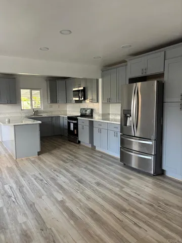 a kitchen with stainless steel appliances granite countertop a refrigerator and stove top oven