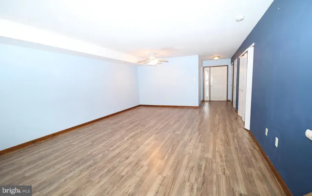 a view of an empty room with wooden floor