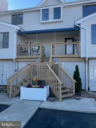 a view of a house with entrance stairs and a balcony