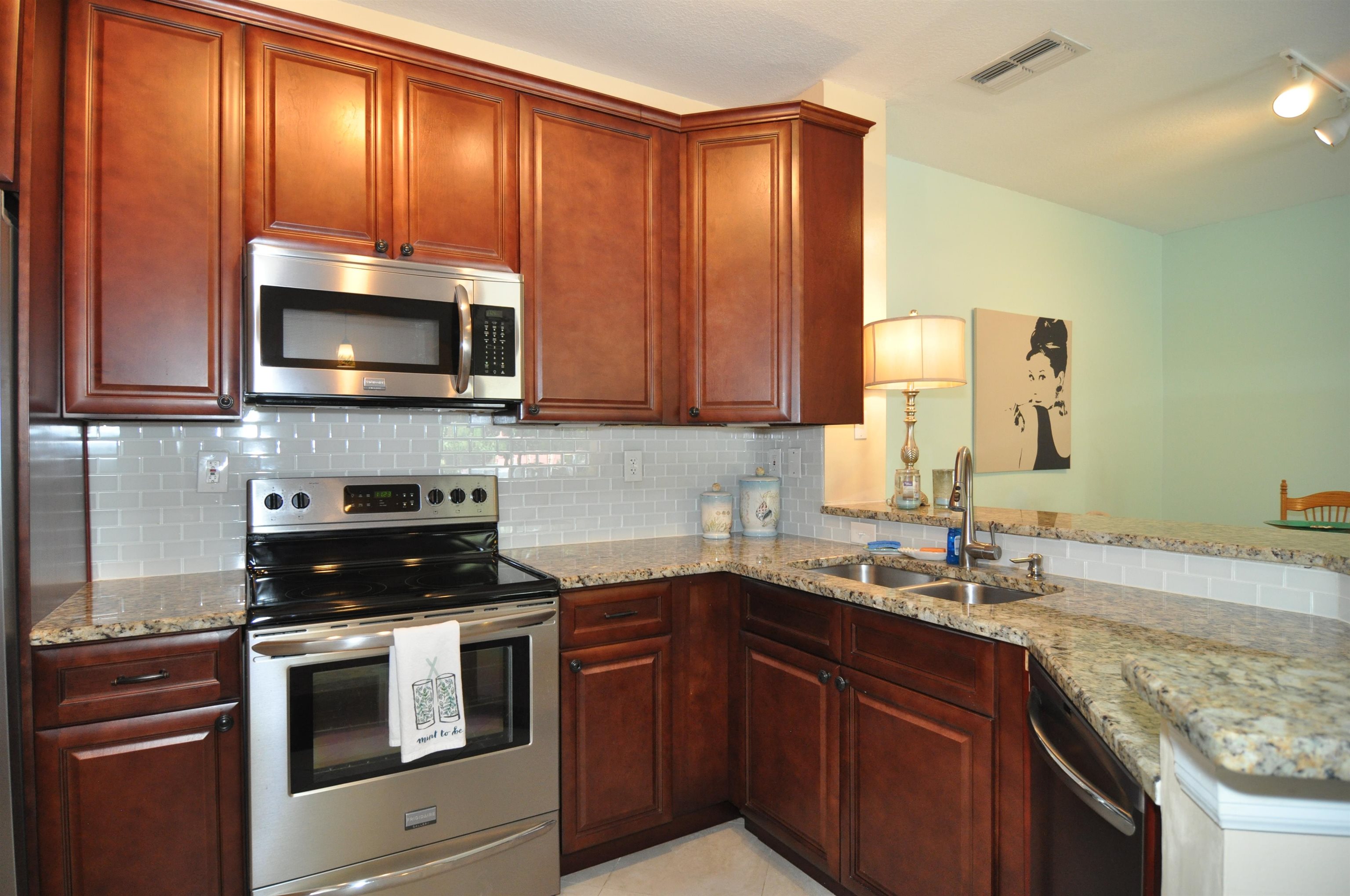 a kitchen with granite countertop wooden cabinets and stainless steel appliances