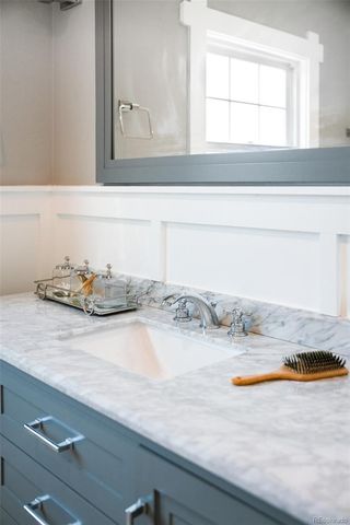a bathroom with a granite countertop sink and mirror