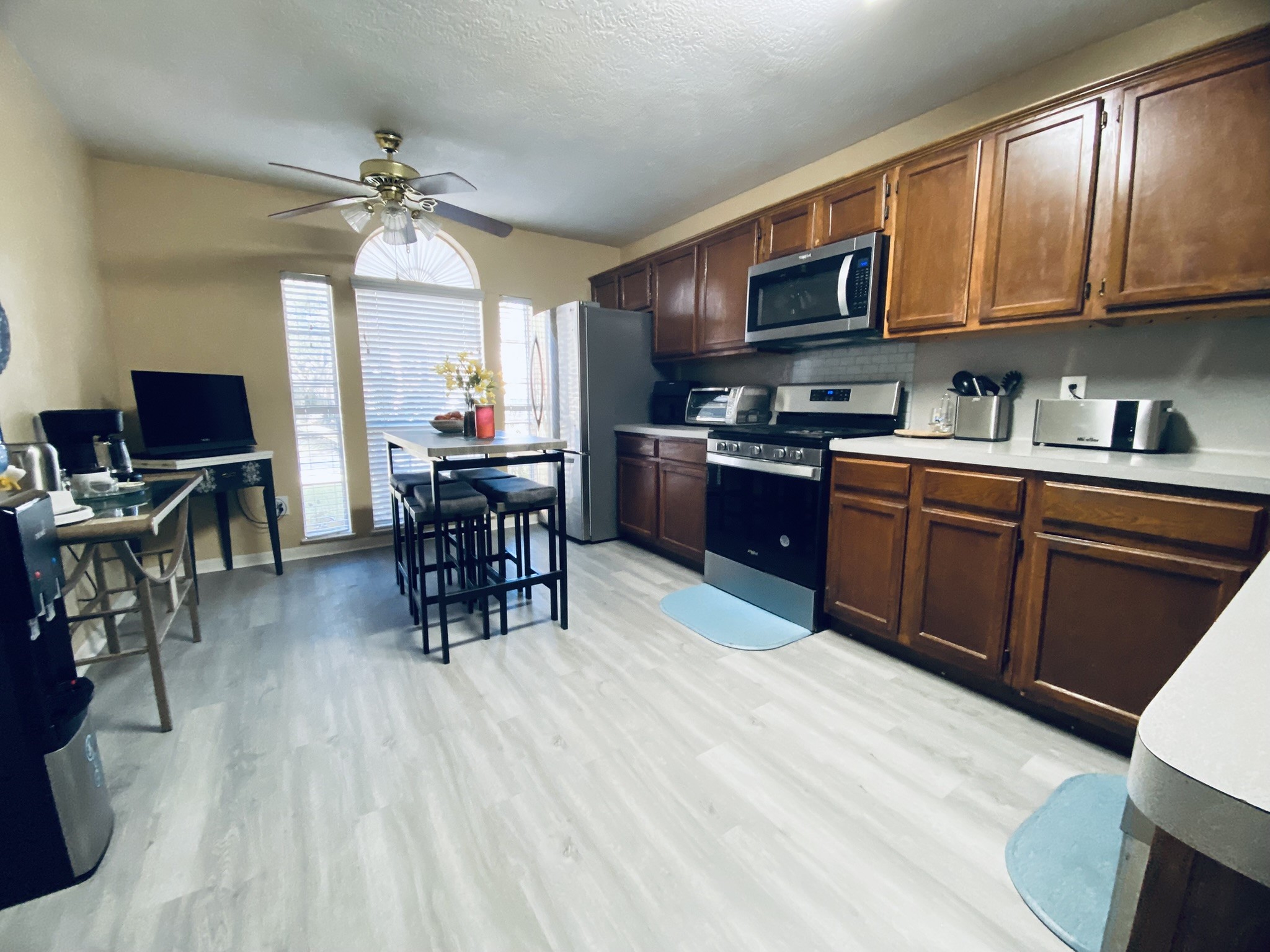 15818 Camp Fire Road Friendswood, TX 77546 - Photo 13 of 36 a kitchen with stainless steel appliances granite countertop a stove top oven a dining table and chairs with wooden floor