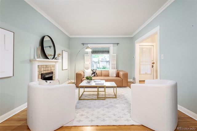 a living room with furniture a fireplace and a large window