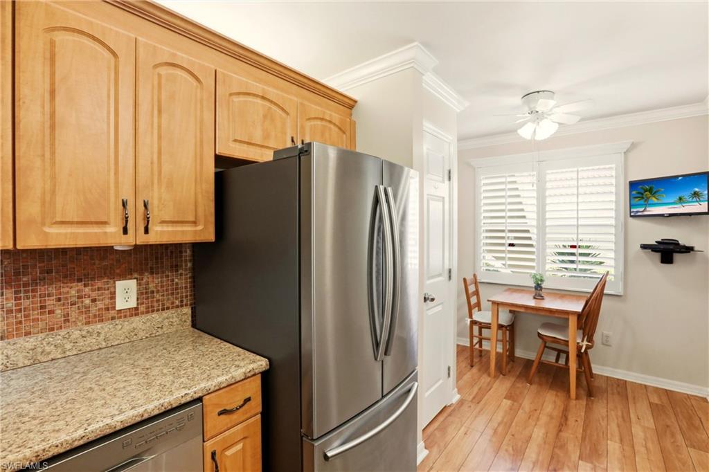 289 Robin Hood Circle, Unit 101 Naples, FL 34104 - Photo 11 of 47 a kitchen with stainless steel appliances granite countertop a refrigerator and a sink