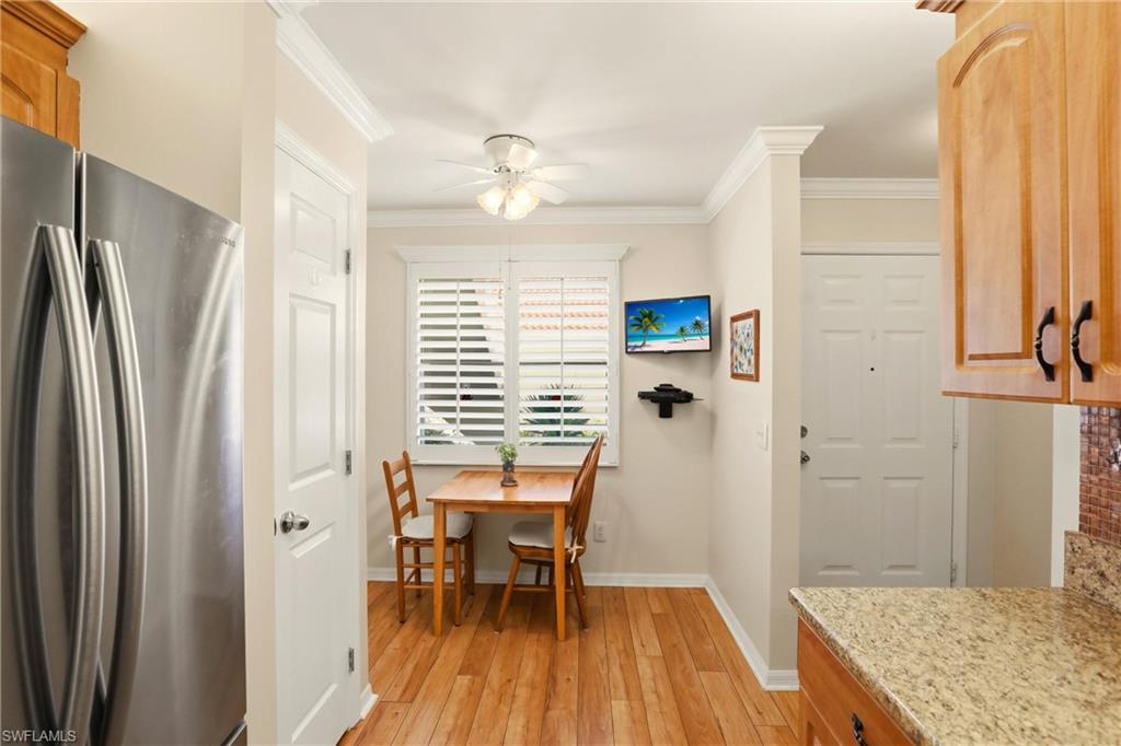 289 Robin Hood Circle, Unit 101 Naples, FL 34104 - Photo 14 of 47 a view of a kitchen with a table and chairs