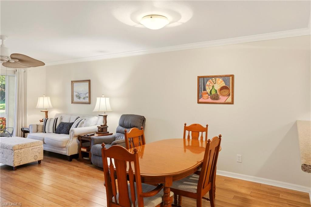 289 Robin Hood Circle, Unit 101 Naples, FL 34104 - Photo 15 of 47 a living room with furniture and a wooden floor