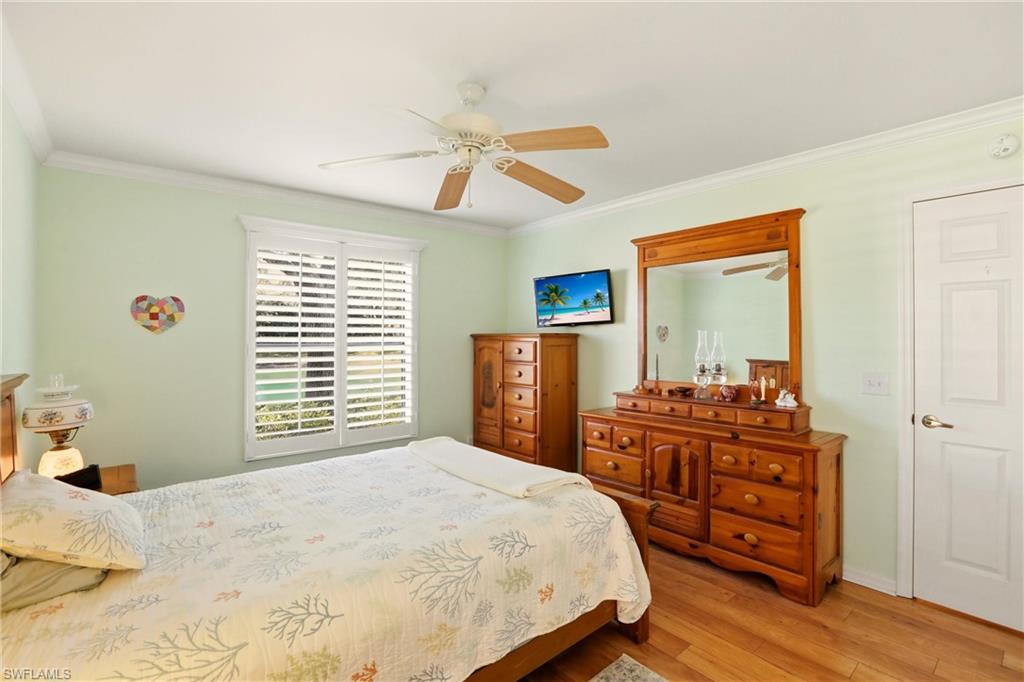 289 Robin Hood Circle, Unit 101 Naples, FL 34104 - Photo 18 of 47 a bedroom with a bed and a dresser in it
