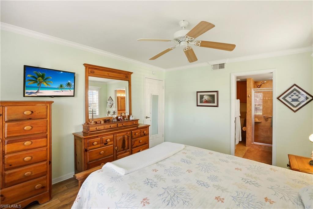 289 Robin Hood Circle, Unit 101 Naples, FL 34104 - Photo 19 of 47 a bedroom with a bed and a dresser