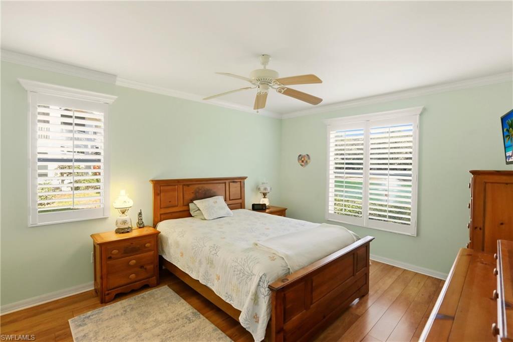 289 Robin Hood Circle, Unit 101 Naples, FL 34104 - Photo 21 of 47 a bedroom with a bed and a chandelier