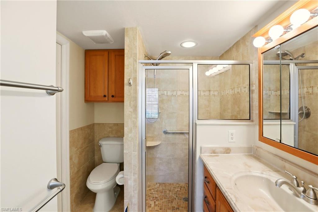 289 Robin Hood Circle, Unit 101 Naples, FL 34104 - Photo 22 of 47 a bathroom with a granite countertop sink toilet and shower