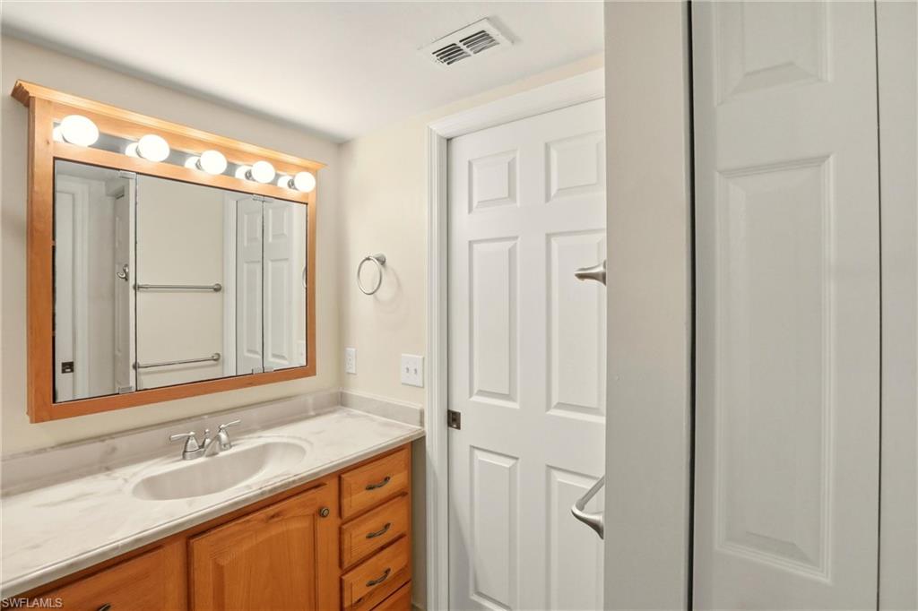 289 Robin Hood Circle, Unit 101 Naples, FL 34104 - Photo 23 of 47 a bathroom with a sink and a mirror