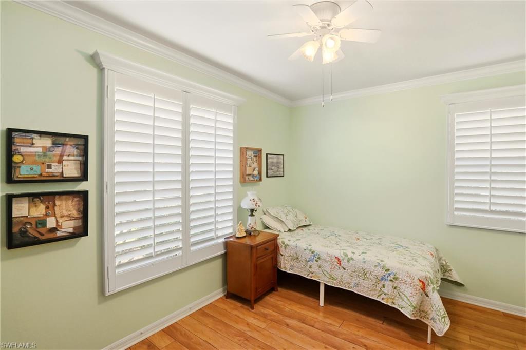 289 Robin Hood Circle, Unit 101 Naples, FL 34104 - Photo 23 of 47 a bedroom with a bed and a window