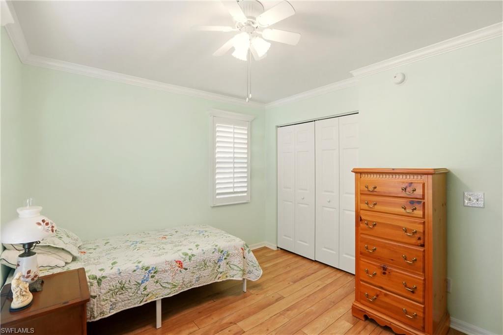289 Robin Hood Circle, Unit 101 Naples, FL 34104 - Photo 24 of 47 a bedroom with a bed and a dresser