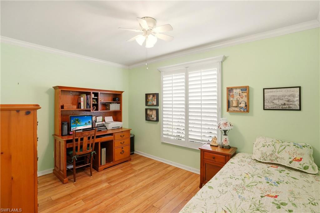 289 Robin Hood Circle, Unit 101 Naples, FL 34104 - Photo 25 of 47 a bedroom with furniture and a chandelier