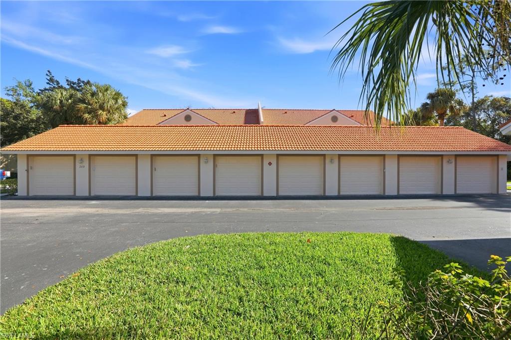 289 Robin Hood Circle, Unit 101 Naples, FL 34104 - Photo 39 of 47 a front view of a house with a garden