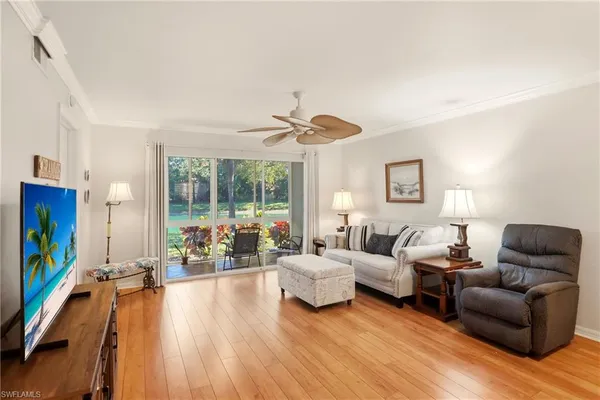 a living room with furniture a flat screen tv and floor to ceiling window