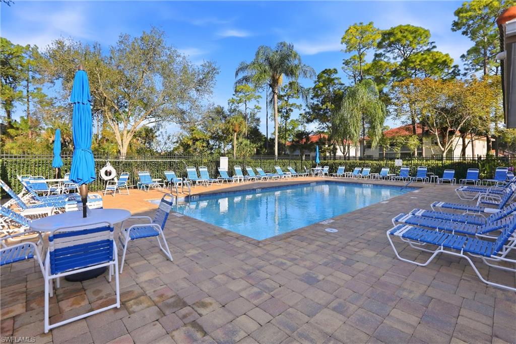 289 Robin Hood Circle, Unit 101 Naples, FL 34104 - Photo 43 of 47 a view of a swimming pool with outdoor seating and trees