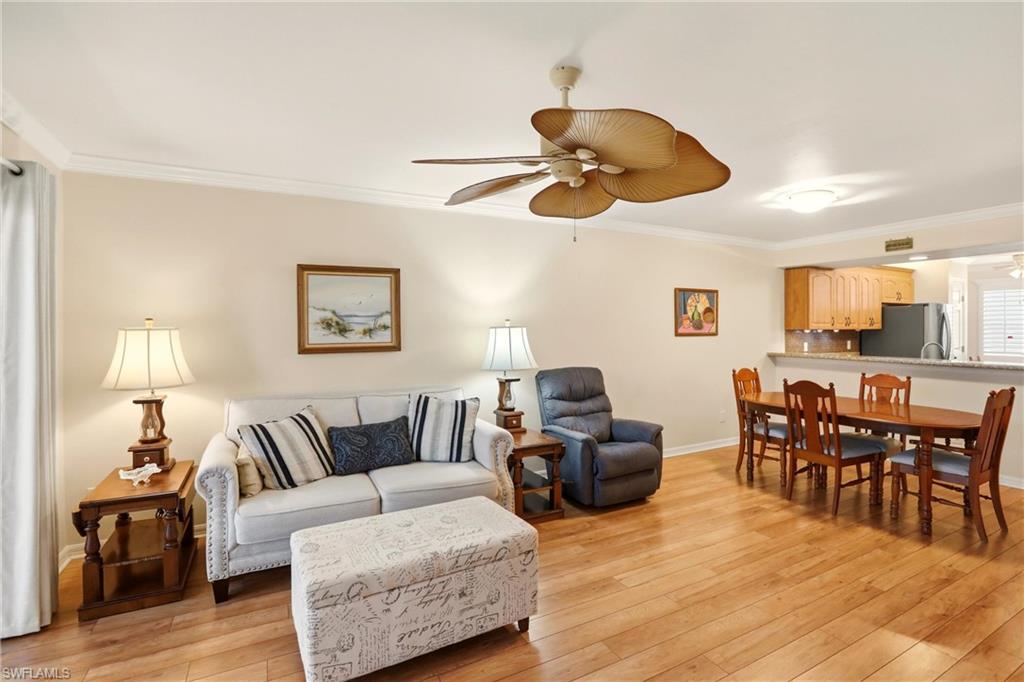 289 Robin Hood Circle, Unit 101 Naples, FL 34104 - Photo 7 of 47 a living room with furniture kitchen view and a wooden floor
