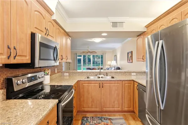 a kitchen with stainless steel appliances granite countertop a refrigerator and a sink