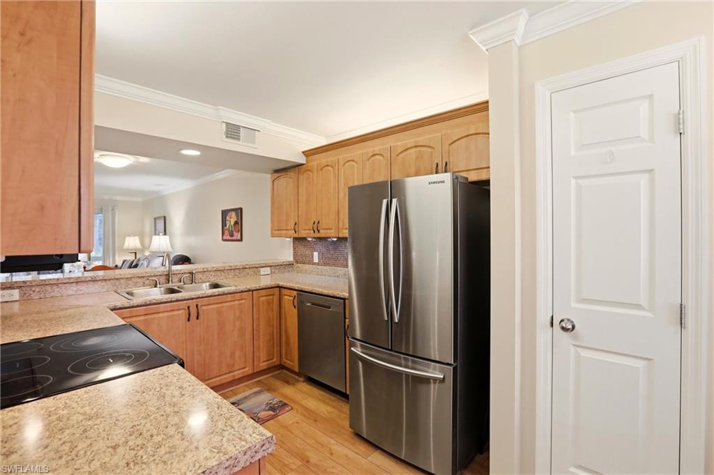 289 Robin Hood Circle, Unit 101 Naples, FL 34104 - Photo 9 of 47 a kitchen with stainless steel appliances granite countertop a refrigerator and a sink