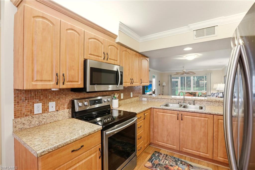 289 Robin Hood Circle, Unit 101 Naples, FL 34104 - Photo 10 of 47 a kitchen with a sink stove and microwave