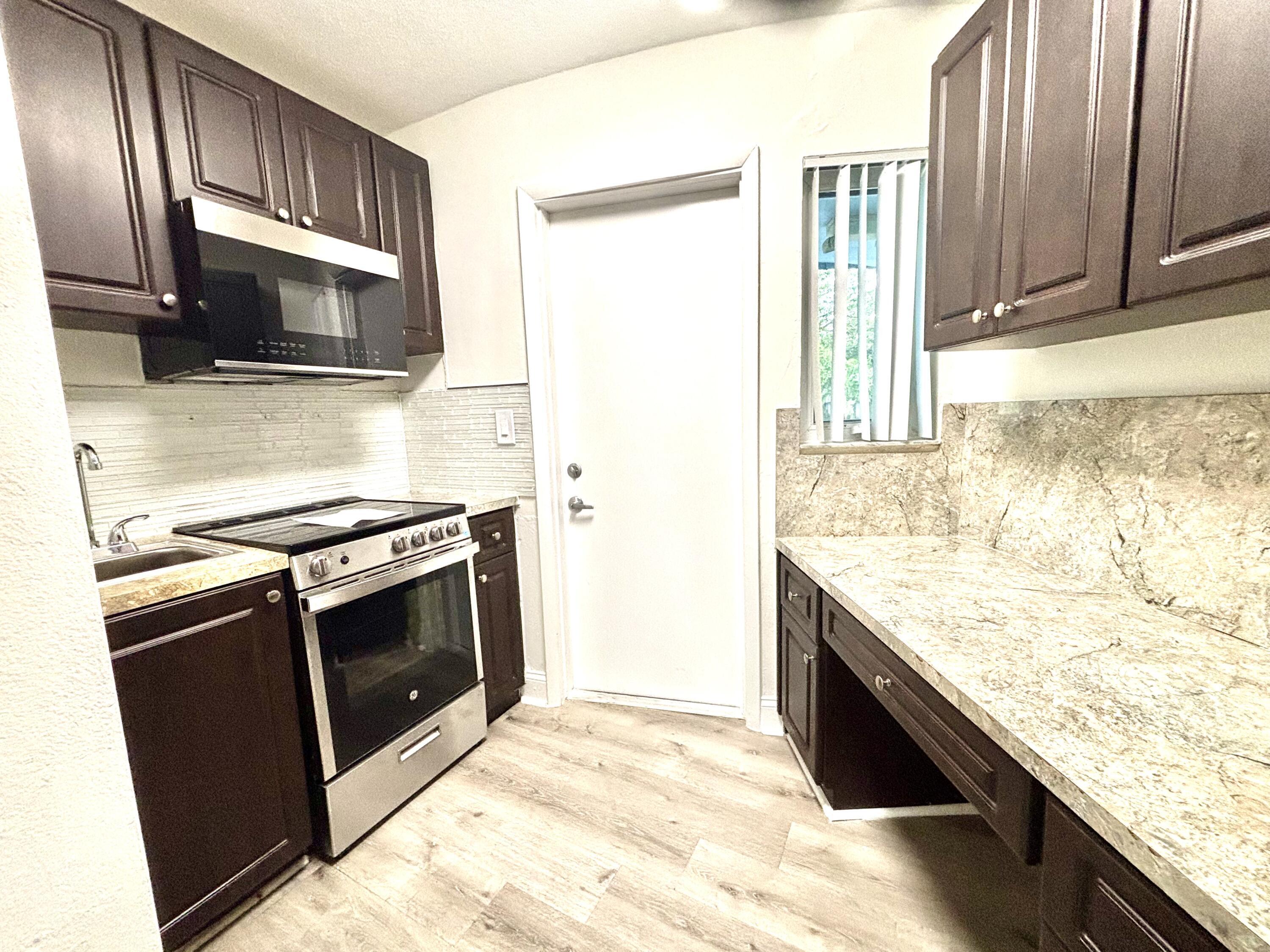 431 West Camino Real Boca Raton, FL 33432 - Photo 9 of 11 a kitchen with granite countertop stainless steel appliances and wooden cabinets