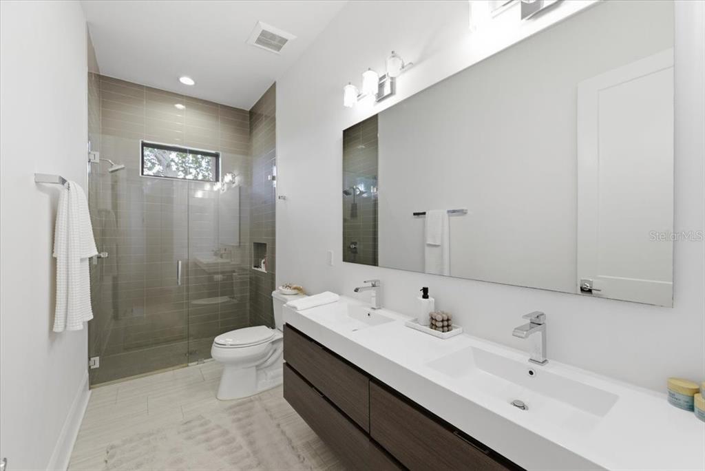 2829 Coastal Range Way Lutz, FL 33559 - Photo 47 of 64 a spacious bathroom with a double vanity sink toilet mirror and shower