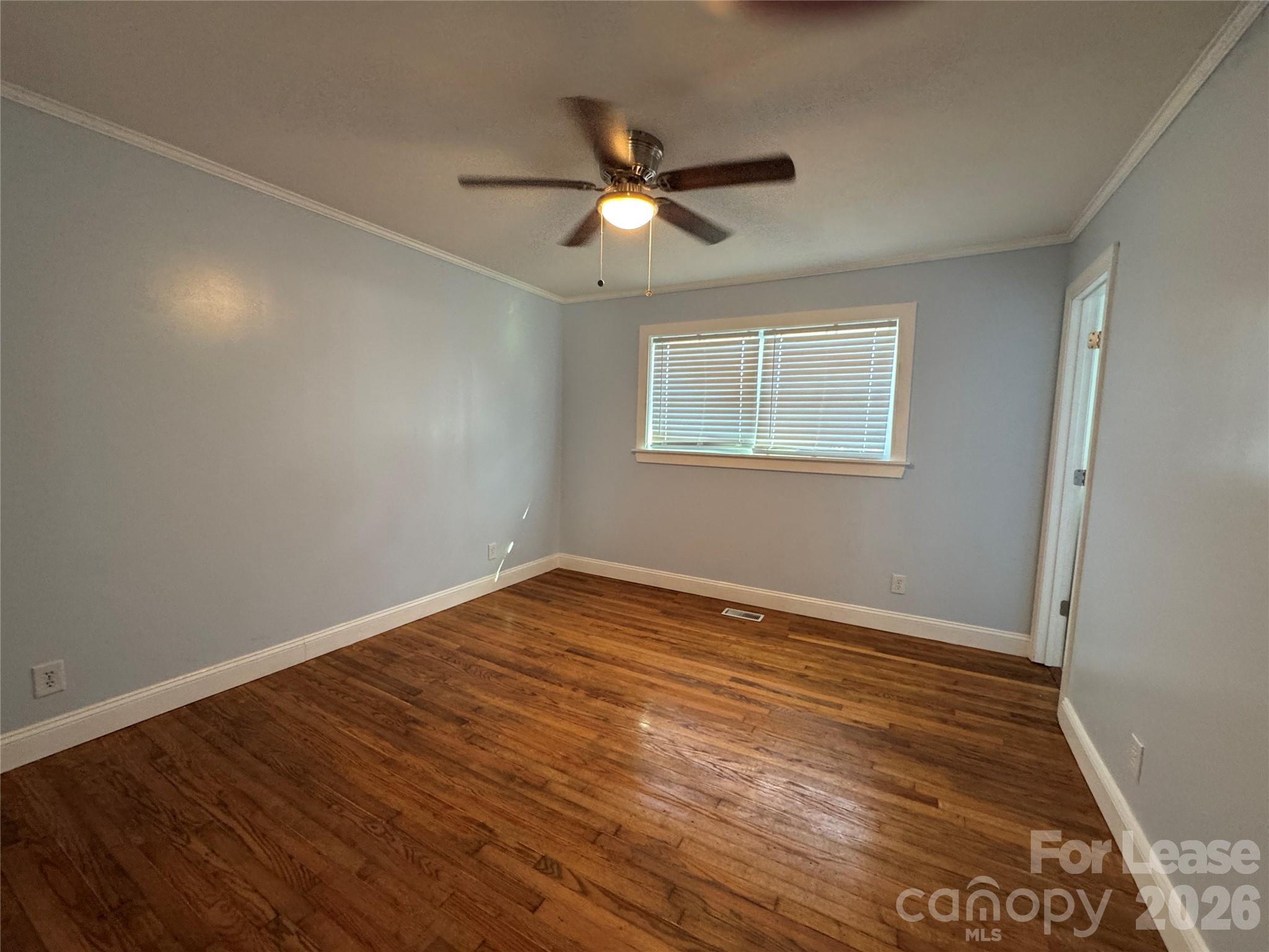 1307 Armstrong Road Belmont, NC 28012 - Photo 8 of 15 an empty room with wooden floor ceiling fan and windows