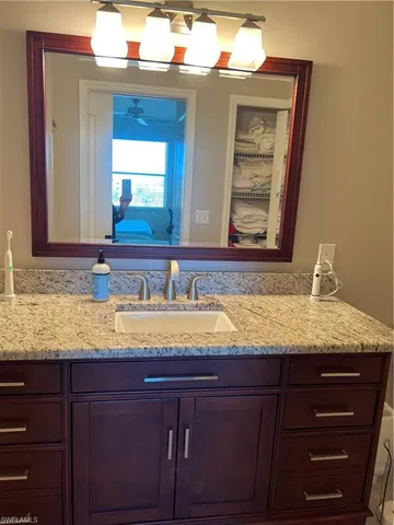 a bedroom with a bed and a lamp on dresser