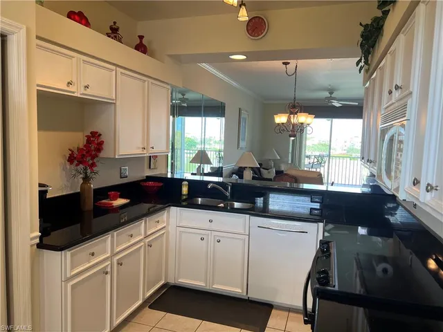 a kitchen with white cabinets and sink