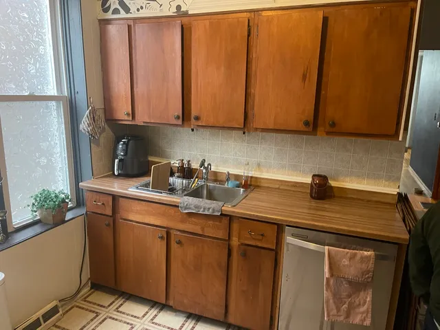 a kitchen with stainless steel appliances granite countertop a sink a refrigerator a stove and white cabinets