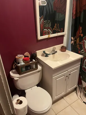 a bathroom with a toilet a sink and a mirror