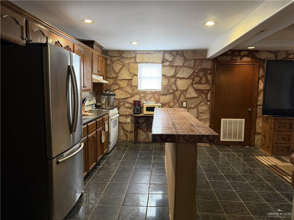 9014 North Abram Road Mission, TX 78574 - Photo 4 of 14 a kitchen with a refrigerator and a sink