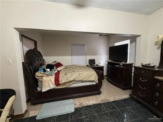 a bedroom with a bed and a flat screen tv