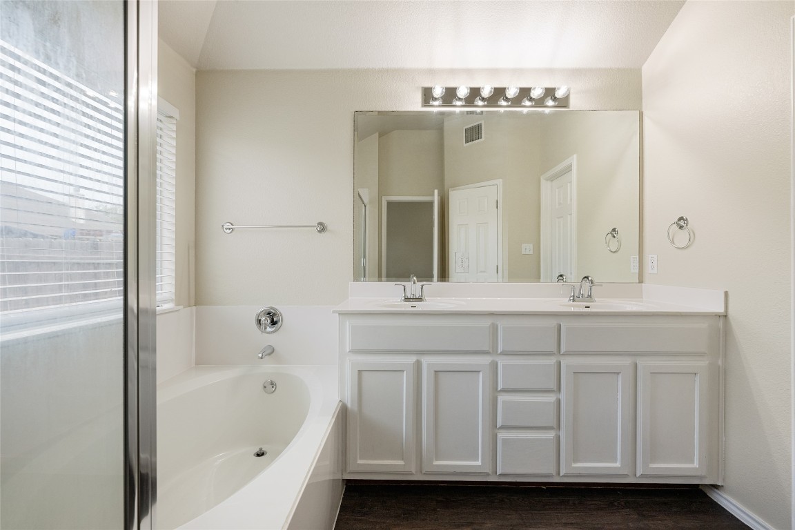 4009 Veiled Falls Drive Pflugerville, TX 78660 - Photo 18 of 26 a bathroom with a double vanity sink mirror and bathtub