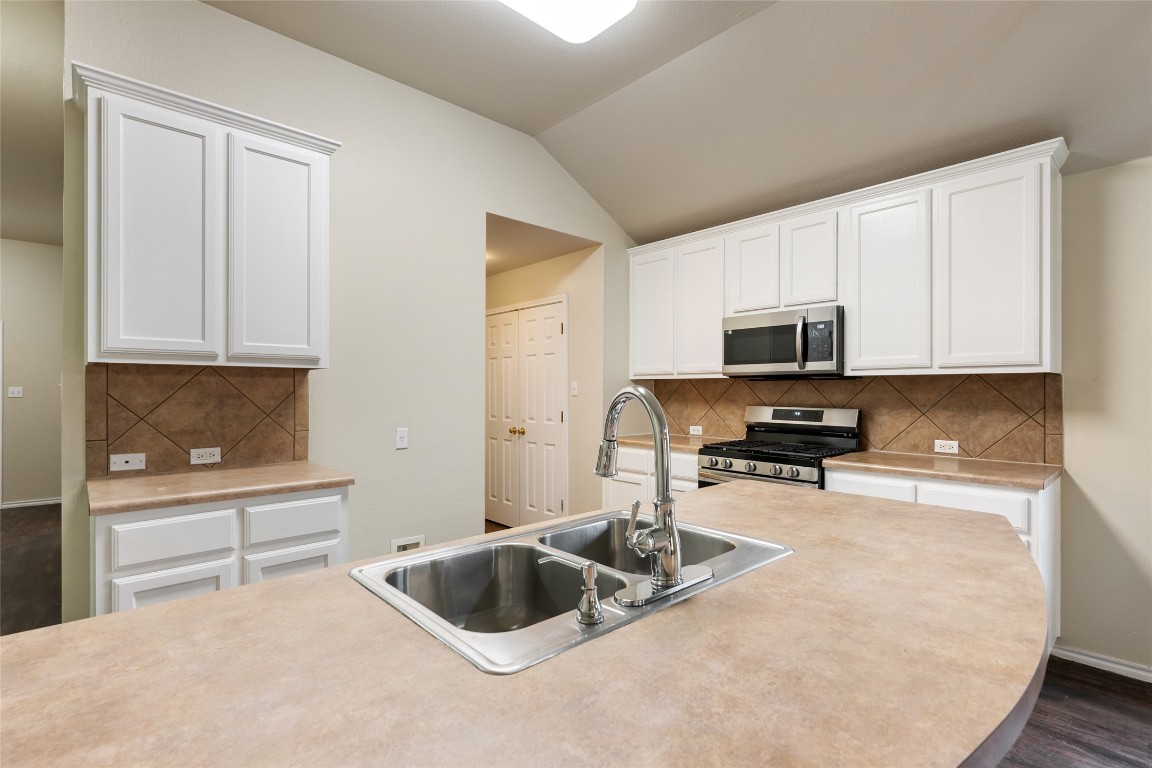 4009 Veiled Falls Drive Pflugerville, TX 78660 - Photo 8 of 26 a kitchen with a sink a stove and cabinets