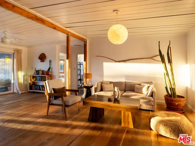 a living room with fireplace furniture and a large window