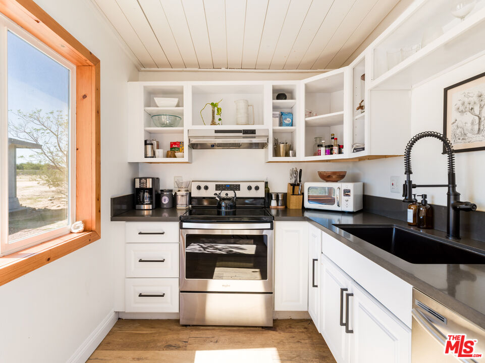 2724 Stonehill Avenue Joshua Tree, CA 92252 - Photo 14 of 65 a kitchen with granite countertop a stove and a sink